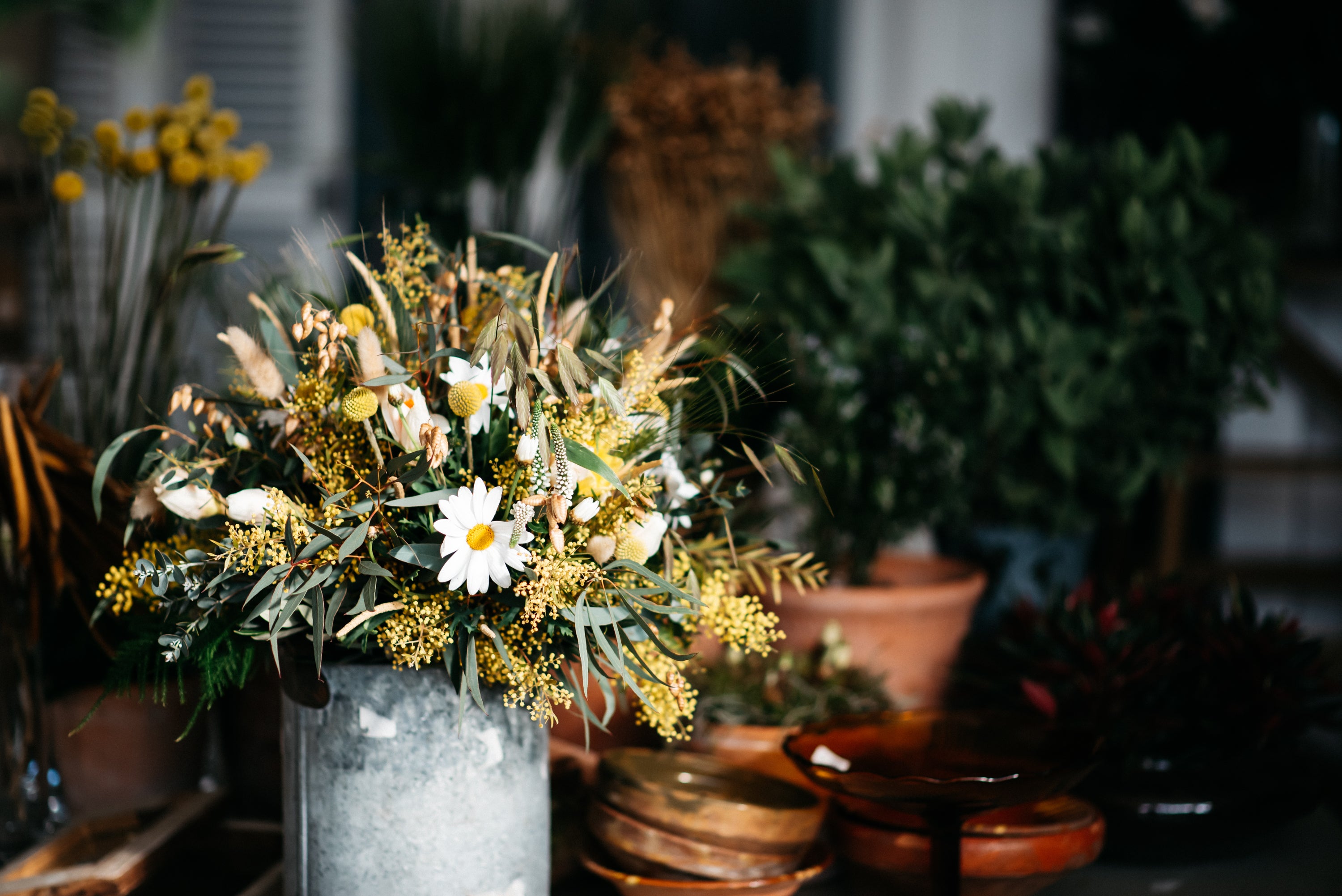 Flower bouquet with daises and yellow flowers in an alluminium basket