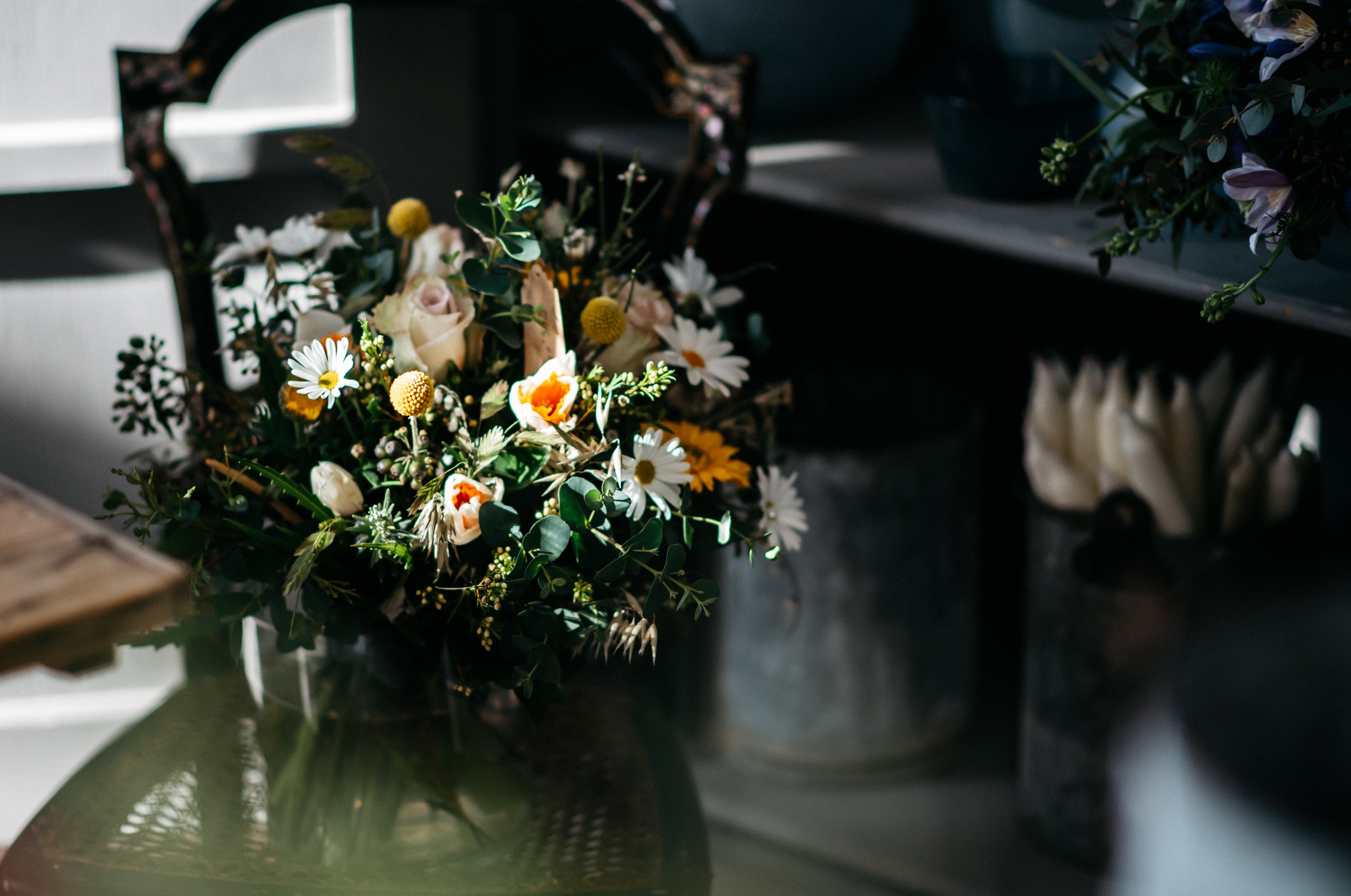 flower bouquet with roses, daises on greens on a chair