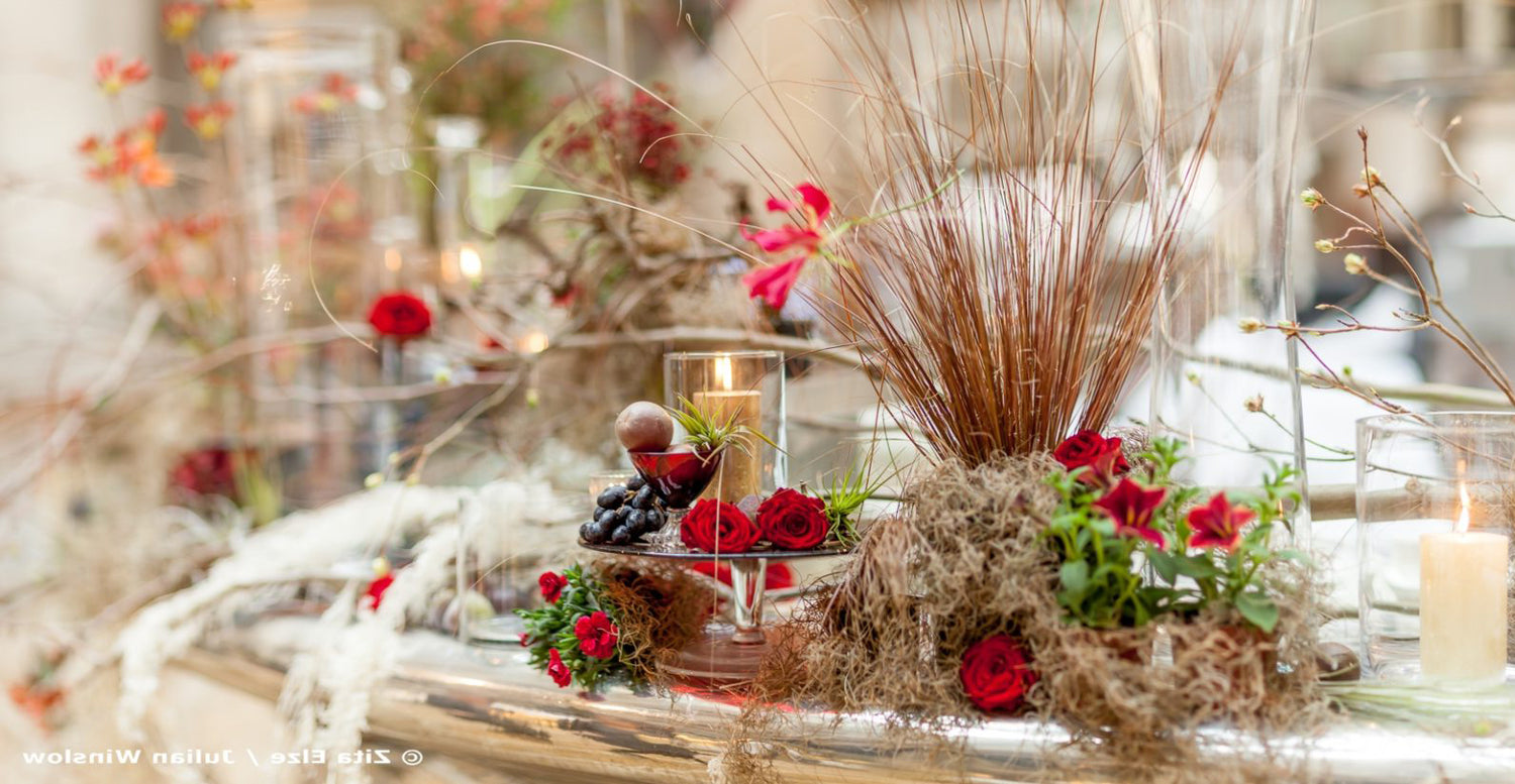 Flowers and leaves arrangement with red roses on a table