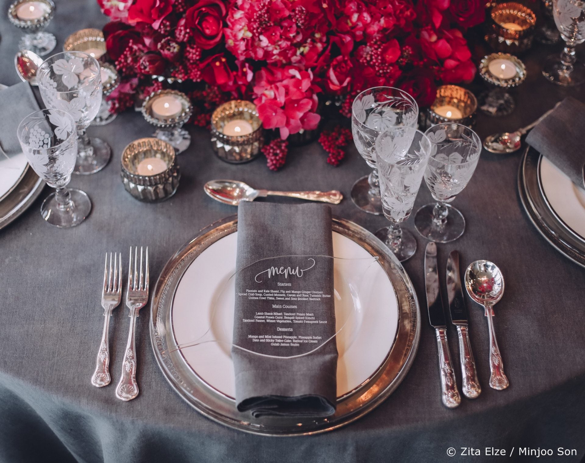 Dine set up with elegant cuttlery grey table cloth and red flowers