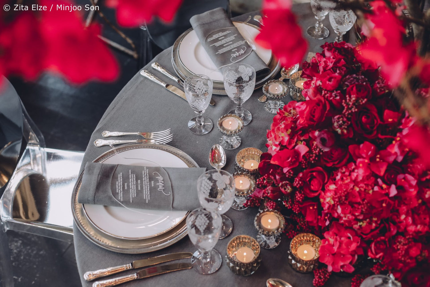 Dine set up with grey tablecloth and red flowers