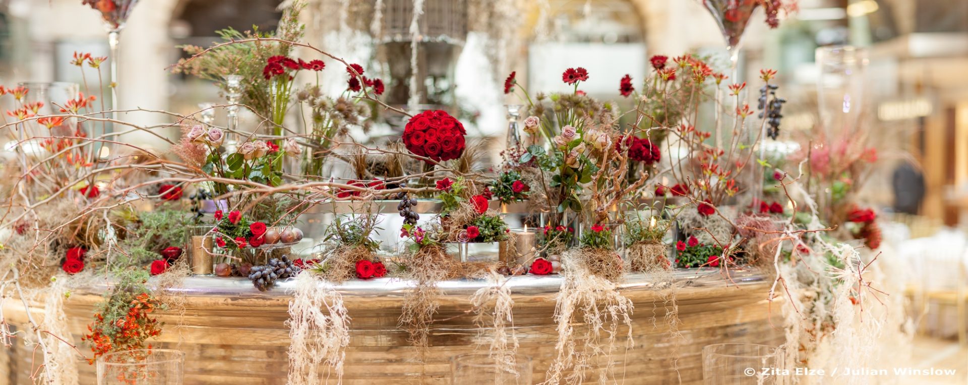 red flowers and branches staged on a counter