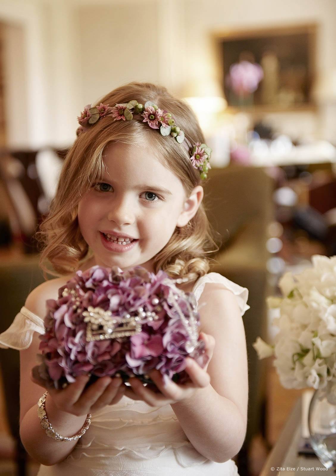 little girl with a flower crown holding a flower bouquet