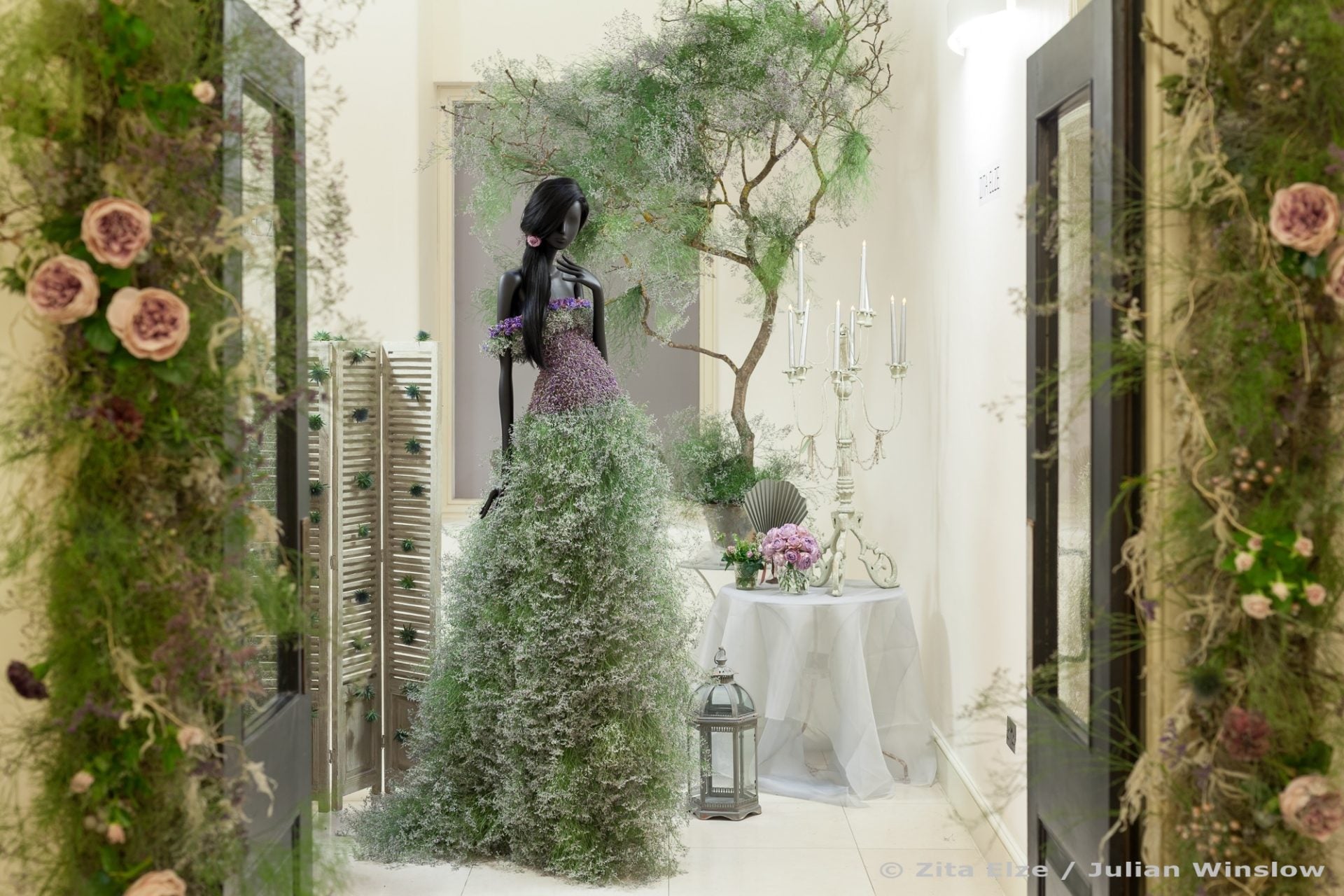black mannequin wearing a gown made of flowers and natural elements