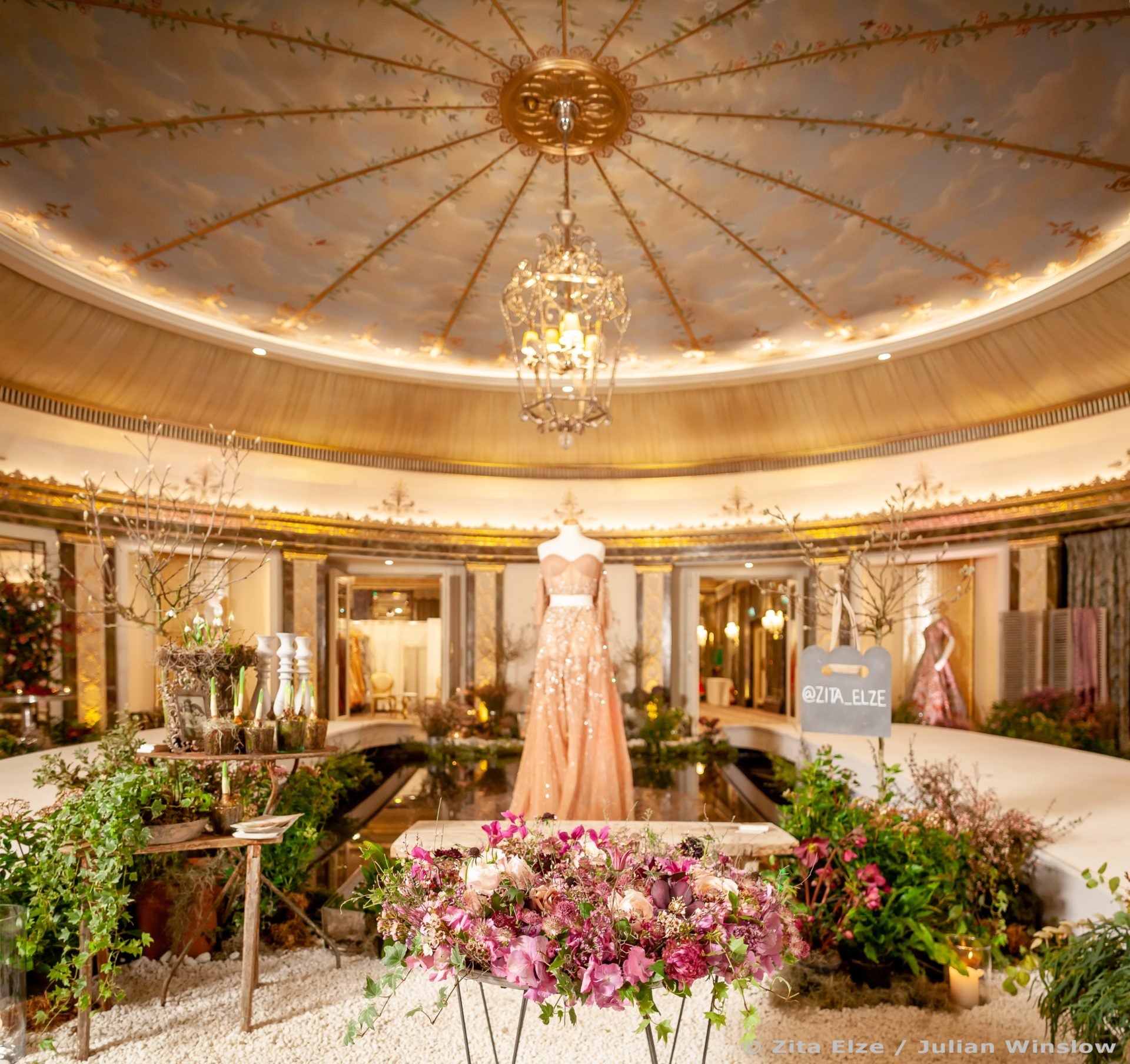 elegant circular golden rrom with a gown in the middle and flowers at the front